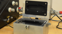 Pressure decay leak test system with custom test chamber, open lid